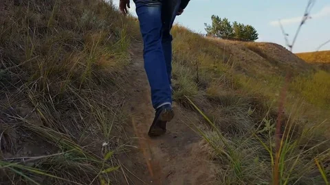 Man is walking up an earthen path Video stock 80447227