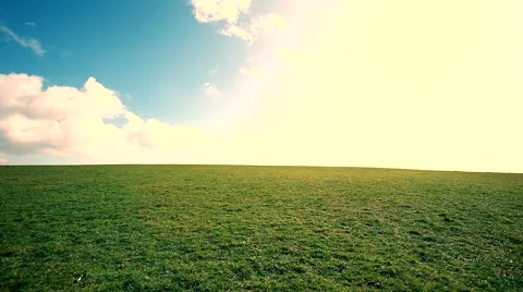 Man walking on the edge of a green hill with beautiful clouds above Stock Footage 48802557