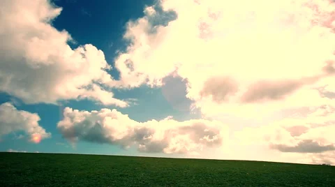 Man walking on the edge of a green hill with beautiful clouds above, Stock Footage 48824094
