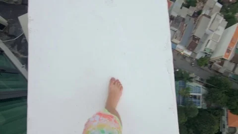 Man walking on the edge of a tall building close-up Video stock 73352811