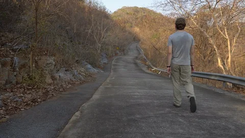 Man Walking on Empty Abandoned Road in Mountains Stock Footage 127940979