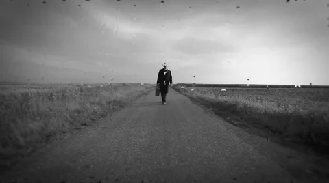 Man walking on empty road on rainy day Stock Footage 40050931