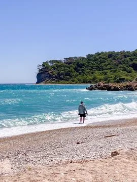 Man Walking on Empty Wild Beach in Summer Stock Photos