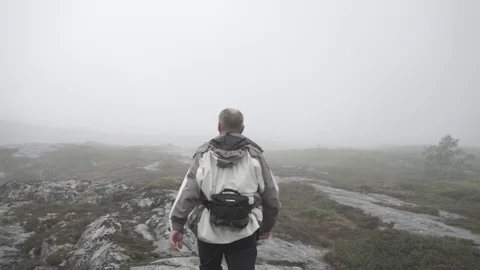 Man walking in epic norwegian mountain fog 4 Stock Footage 89648312
