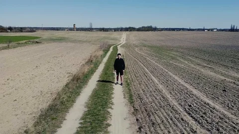 Man walking in the field drone video Stock Footage 128545494