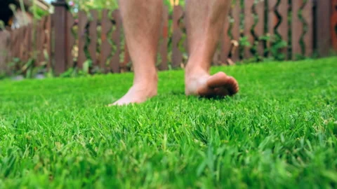 Man walking on freshly cut grass Stock Footage 197324474