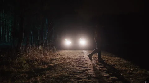 Man Walking in front of Car Headlights Video stock 259129759