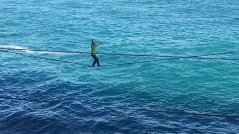Man Walking On High-Wire over sea Stock Footage