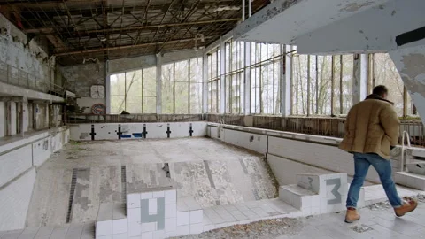 Man walking inside the abandoned Azure swimming pool in the ghost town of Stock Footage 332830078