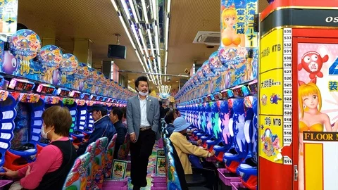 A man walking inside about to play the arcade game in Osaka Japan Stock Footage 126949458