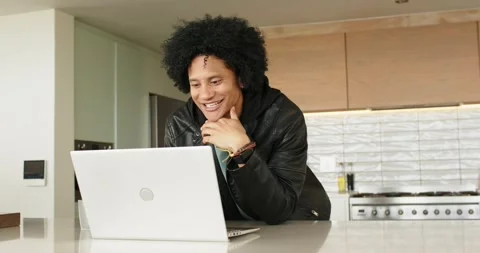 Man walking into kitchen placing laptop on countertop leaning smiling nodding Stockbeeldmateriaal 345062830