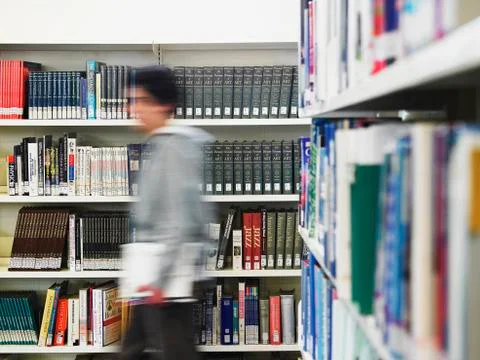 Man Walking In Library Fotos de archivo