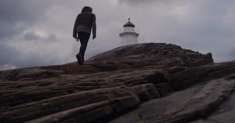 Man walking up a limestone rock to a lighthouse. Stock-Footage 106121750