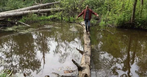 Man is walking on a log Stock Footage 94562198