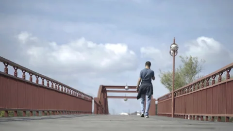 Man walking on metal bridge Stock Footage 166239556