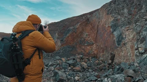 Man walking at mountains with digital camera and backpack Stock Footage 145684418