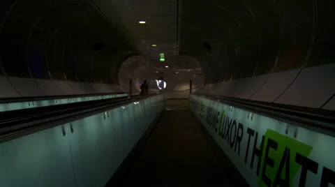 Man walking on moving sidewalk. Smooth straight dolly shot of futuristic tunnel Stock Footage 42490896