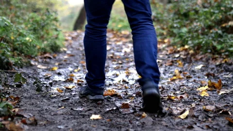 Man walking on a muddy path avoiding the puddles Stock Footage 143599956