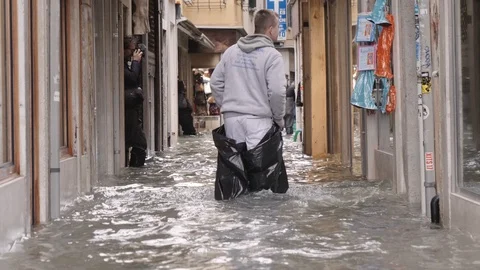 Man walking on the narrow streets during the Venice flood 스톡 동영상 120035535