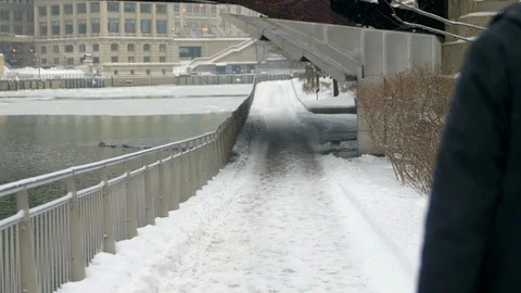 Man walking next to Chicago River in the snow Stock Footage 86529021