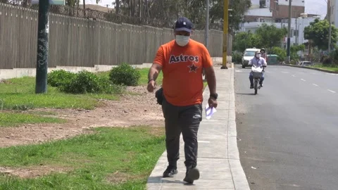 A man walking next to cyclists in the city wearing a mask Stock Footage 149207192