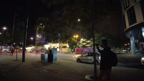 Man Walking at Night Drinking a Beer Bottle in the Streets of the city Stock Footage 180698915