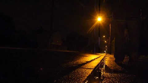 Man Walking at Night in Rain Stock Footage