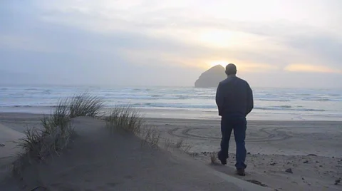 Man Walking to Ocean Sunset Stock Footage 2579754