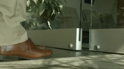 Man walking Into an office lobby through a glass door 库存影片 61236622