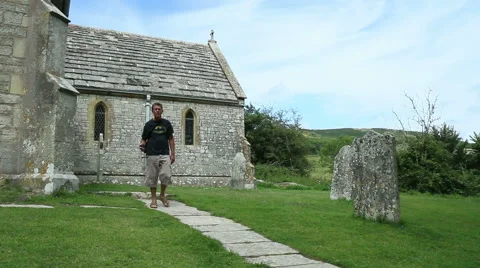 Man walking by old churchyard Stock Footage 40720762