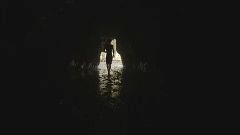 Man walking out of a cave Stock Footage 79789938