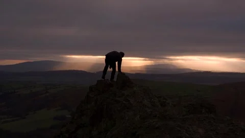 A man walking out onto a cliff edge to watch sunrise Vídeo Stock 262446740