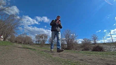 Man walking outdoors, using a phone. Stock-Footage 105804130