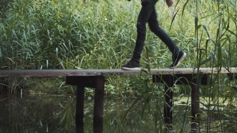 Man Walking Over A Bridge Within The Forest With Lots Of Water Around Him Stock Footage 130676865