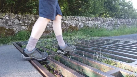 Man Walking Over A Cattle Grid In The Countryside Stock Footage 201341148