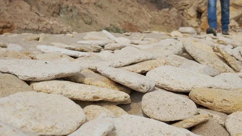 Man walking over rocks and sand Stock Footage 106706505