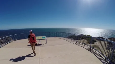 Man walking over steep red sea cliffs of Kalbarri NP in Australia Stock Footage 70967535