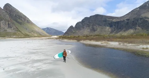 Man walking with paddleboard on beach Stock Footage 85961976