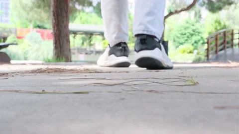 A man walking in a park close-up focus on shoes Stock Footage 156719825
