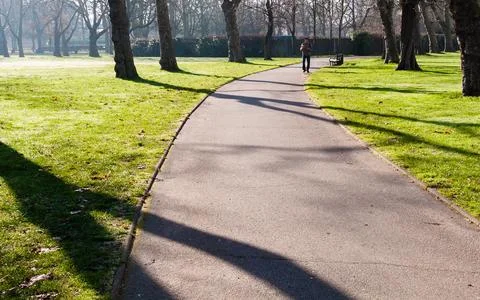 Man walking in the park path Stock Photos