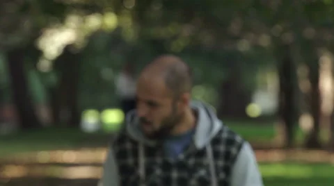 Man walking in the park sees something that upsets him Stock Footage 68545137