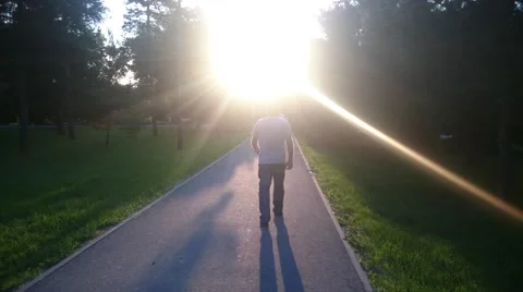 Man walking in a park at sunset Stock Footage 51167402