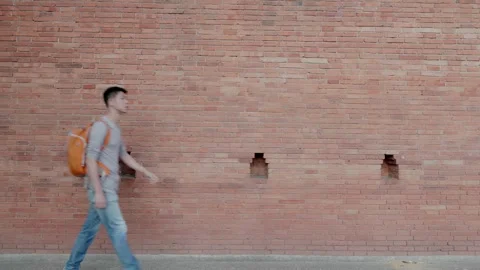 Man Walking Past Brick Wall Stock Footage 314570127