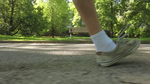 Man Walking Past Park Bench In Park Ground View Stock Footage 249772111
