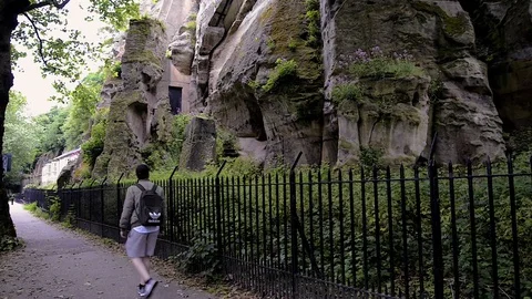 Man walking past the rocks at Nottingham Castle. Видео 129883659