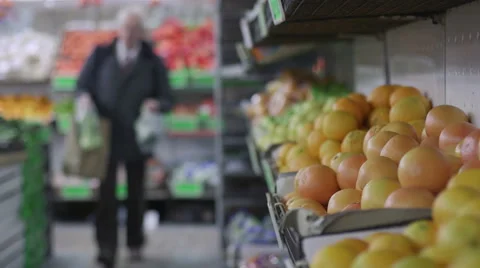 Man Walking Past Shelf of Oranges in Market Stock Footage 55827713