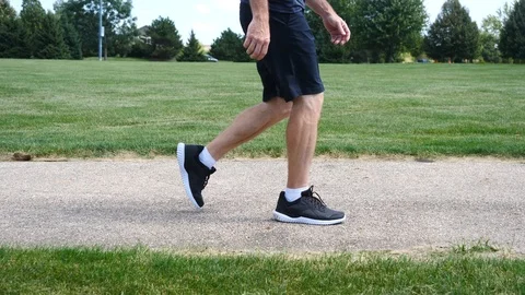 Man walking by on a path in a park in slow motion, 4k. Stock Footage 115273481