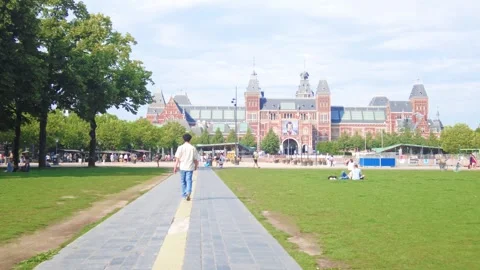 Man walking pathway towards the rijksmuseum on a patch of grass in the Stock Footage 342726424
