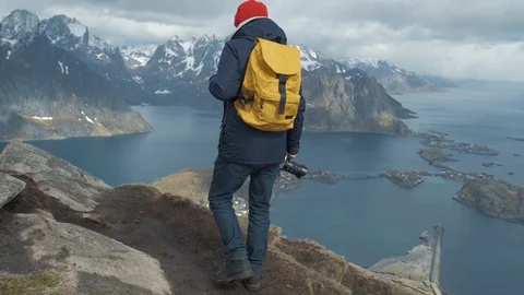 Man walking at the peak of a mountain at sunset in slow motion . Wearing a Stock Footage 109374980