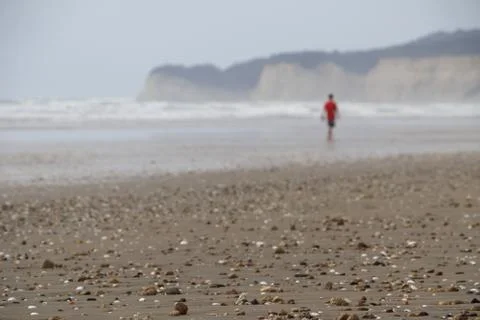 Man walking on pebbly beach Stock-Fotos